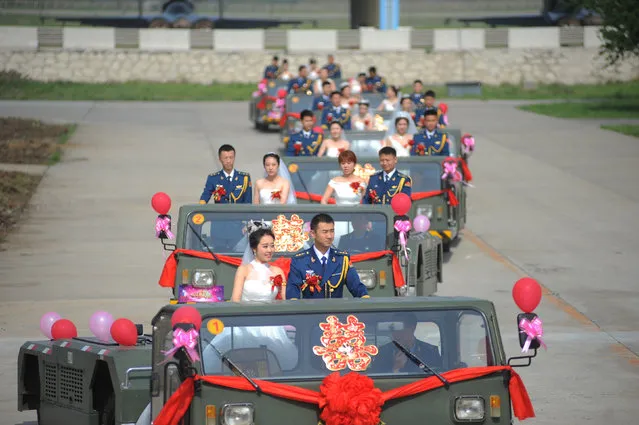 Soldiers of China's Liberation Army (PLA) air force stand on military vehicles as they attend a group wedding in Anshan, Liaoning, China, May 21, 2016. (Photo by Reuters/Stringer)
