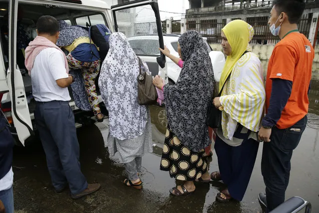 In this June 8, 2017 photo, Rohaina Salic, second from right, waits to board their vehicle with family and relatives at the provincial government headquarters in Marawi city, southern Philippines. It was during a lull in the fighting that Salic first heard it, the bellow of a distant voice telling civilians trapped in the war-shaken city of Marawi they could finally emerge from their homes. It’s unclear how many people remain trapped in Marawi. Authorities have put the figure this week at anywhere from 100 to 2,000. (Photo by Aaron Favila/AP Photo)