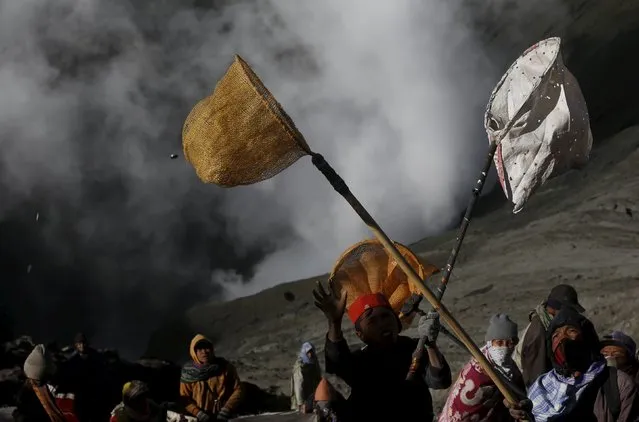 Villagers hold nets in an attempt to catch coins thrown as offerings by Hindu worshippers into the crater during the Kasada Festival at Mount Bromo in Probolinggo, Indonesia's East Java province, August 1, 2015. (Photo by Reuters/Beawiharta)