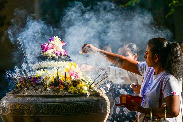 A Buddhist devotee offers prayers on the occasion of 'Poya' a religious festival to mark the full moon, at a temple in Kelaniya on September 17, 2024. (Photo by Ishara S. Kodikara/AFP Photo)