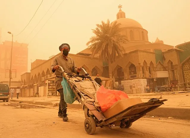 A man pushes a cart during a sandstorm in Baghdad, Iraq, Monday, May 16, 2022. (Photo by Hadi Mizban/AP Photo)