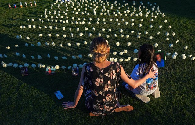 People gather to honor victims of gun related deaths at Public Square Park in Nashville, Tennessee, on September 20, 2024. The vigil is organized by the Tennessee Hispanic Action Network in honor of victims of gun violence, including 18-year-old Yasser Paz, who was shot and killed outside of a nightclub earlier this month. (Photo by Seth Herald/AFP Photo)