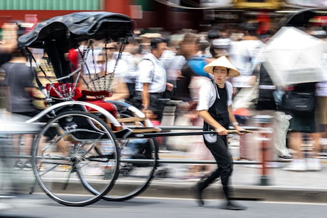 A rickshaw driver works outside Sensoji Temple at the Asakusa district of Tokyo on July 31, 2024. (Photo by Philip Fong/AFP Photo)