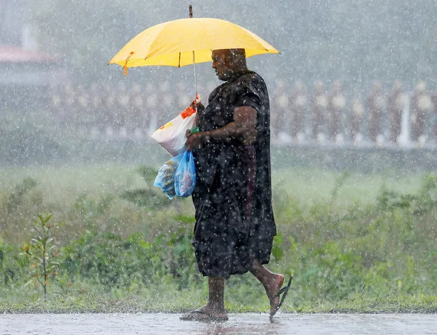 A Buddhist monk walks in the rain on a main road in Colombo, Sri Lanka June 10, 2016. (Photo by Dinuka Liyanawatte/Reuters)