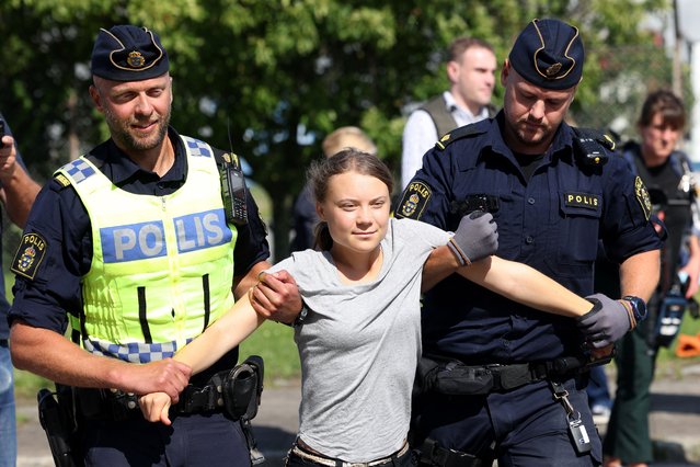 Climate activist Greta Thunberg is carried away by police officers after she took part in a new climate action in Oljehamnen in Malmo, Sweden on July 24, 2023, shortly after the city's district court convicted and sentenced her to a fine for disobeying police at a rally last month during a climate action in the Norra hamnen neighbourhood of Malmo. Thunberg was fined on Monday for disobeying police at a rally last month, but said she acted out of necessity due to the climate crisis. (Photo by Andreas Hillergren/TT News Agency via AFP Photo)