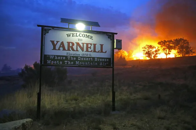 A wildfire burns homes in Yarnell, Ariz. on Sunday, June 30, 2013. An Arizona fire chief says the wildfire that killed 19 members of his crew near the town was moving fast and fueled by hot, dry conditions. The fire started with a lightning strike on Friday and spread to 2,000 acres on Sunday amid triple-digit temperatures. (Photo by David Kadlubowski/AP Photo/The Arizona Republic)