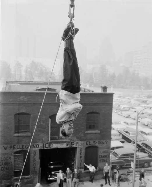 The Amazing Randi, 27-year-old Canadian escape artist is suspended in the air with the help of a crane, June 7, 1956 in New York, at 49th St. and First Avenue. He was tied in a strait jacket and escaped in 1 minute, 40 seconds. (Photo by Anthony Camerano/AP Photo)