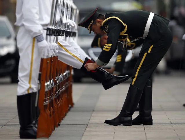 Members of an honor guard clean their boots as they get ready for a welcoming ceremony outside the Great Hall of the People in Beijing. (Photo by Kim Kyung-Hoon/Reuters)