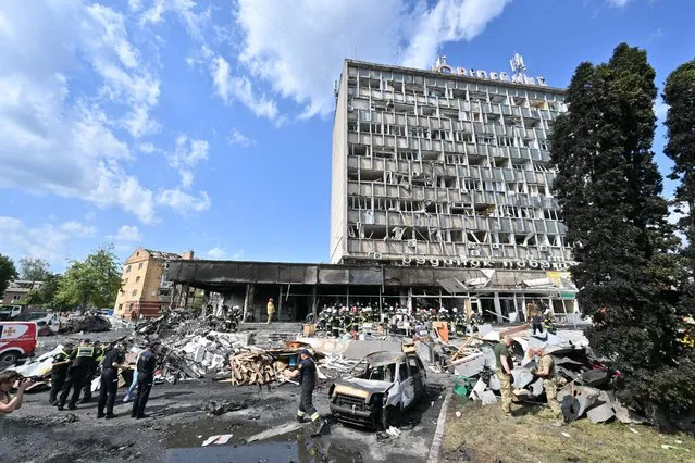 Firefighters remove rubbles out of a damaged building following a Russian airstrike in the city of Vinnytsia, west-central Ukraine on July 14, 2022. At least 20 people were killed Thursday by Russian strikes on a city in central Ukraine, bombings described as “an openly terrorist act” by Ukrainian President Volodymyr Zelensky. (Photo by Sergei Supinsky/AFP Photo)