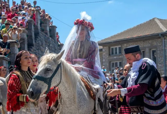 Bride Elena Durakovska on horseback, accompanied by her relatives arrives at the house of the bridegroom during the Galicnik wedding ceremony in the village of Galicnik, Republic of North Macedonia, 17 July 2022. Every year, the villagers of Galicnik celebrate a public summer wedding on the Orthodox day of the Patron Saint Petrovden (St. Peter's day). Many rituals such as music and dances are performed during this centuries-old tradition. (Photo by Georgi Licovski/EPA/EFE/Rex Features/Shutterstock)