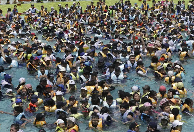 People crowd the Caribbean Bay swimming pool as they try to escape a heat, in Yongin, South Korea, Sunday, July 10, 2016. A heat wave warning was issued in Seoul as temperatures soared above 33 degrees Celsius (91.4 degrees Fahrenheit). (Photo by Ahn Young-joon/AP Photo)