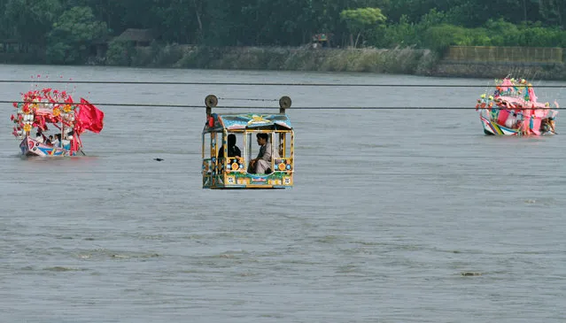 Local tourists use a cable car and boats to cross the Sardaryab river in Charsadda, Pakistan August 1, 2017. (Photo by Fayaz Aziz/Reuters)