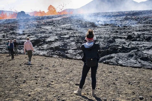 People visit the scene of the newly erupted volcano taking place in Meradalir valley, near mount Fagradalsfjall, Iceland on August 4, 2022. (Photo by Jeremie Richard/AFP Photo)