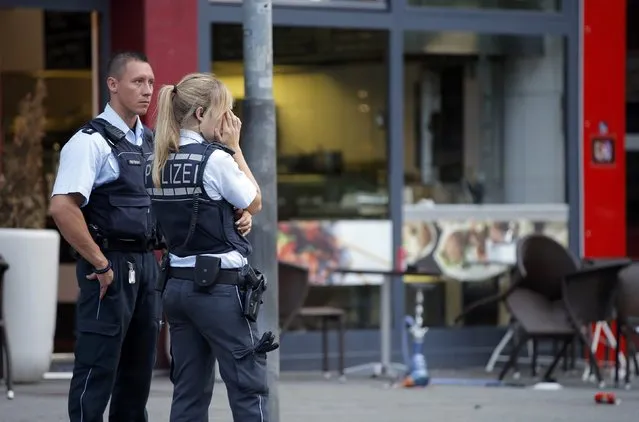 Police stand outside where a 21-year-old Syrian refugee killed a woman with a machete and injured two other people in the city of Reutlingen, Germany July 24, 2016. (Photo by Vincent Kessler/Reuters)