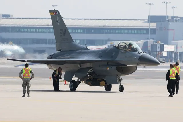 Airport personnel guide an F-16C Fighting Falcon form the 79th Fighter Squadron, Shaw Airforce Base, South Carolina, during media day for the Canadian International Air Show at Pearson Airport in Toronto, Ontario, September 3, 2015. (Photo by Louis Nastro/Reuters)