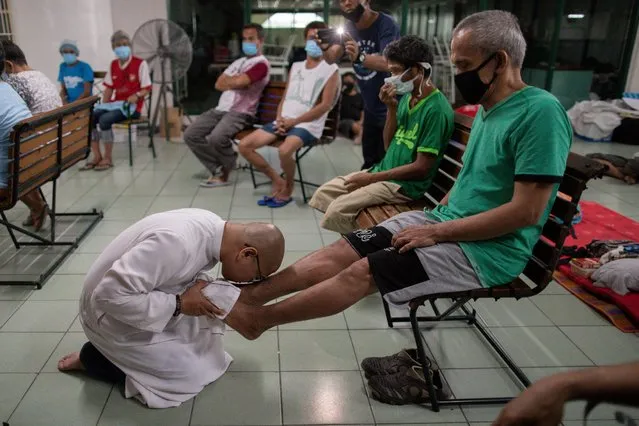 A Catholic priest kisses the feet of a homeless man during a traditional Holy Thursday ceremony at a university that temporirily shelters the homeless amid the lockdown to contain the coronavirus disease (COVID-19), in Manila, Philippines, April 9, 2020 . (Photo by Eloisa Lopez/Reuters)