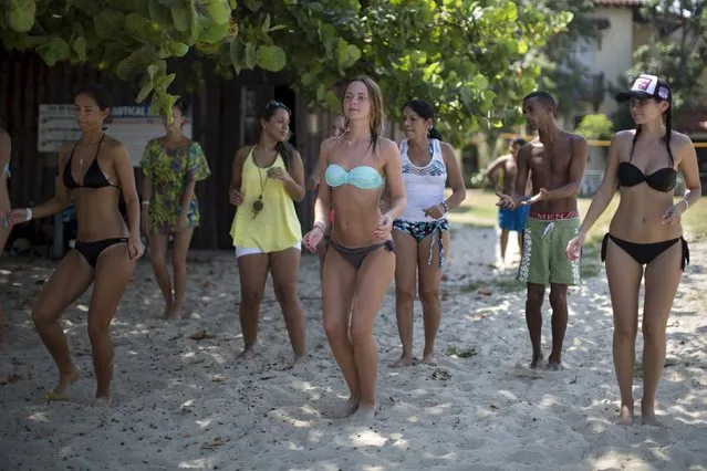 Tourists dance during a salsa class at the beach in Varadero, Cuba, August 26, 2015. (Photo by Alexandre Meneghini/Reuters)