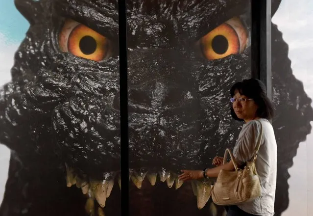 A woman walks past a face of Godzilla at the Godzilla exhibition in Yokohama, suburb of Tokyo, to promote latest movie of the monster released in July on August 17, 2016. The exhibition will last until September 4. (Photo by Toru Yamanaka/AFP Photo)