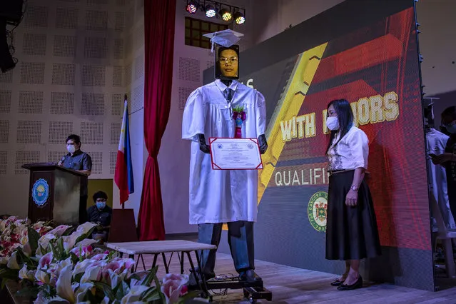 The face of a graduating student is displayed on a tablet attached to a robot during a “cyber graduation” ceremony at a school on May 22, 2020 in Taguig, Metro Manila, Philippines. Robots represented some 179 graduating students of the Senator Rene Cayetano Science and Technology High School during a graduation ceremony that was streamed online, as mass gatherings remain prohibited in the country under the Philippine government's lockdown to curb the spread of the coronavirus. The robots were developed by alumni of the school's robotics club, which used tablets to display the faces of the graduating students as they “marched” on stage to receive their diplomas. The Philippines' Department of Health has so far reported 13,434 cases of the coronavirus in the country, with at least 846 recorded fatalities. (Photo by Ezra Acayan/Getty Images)