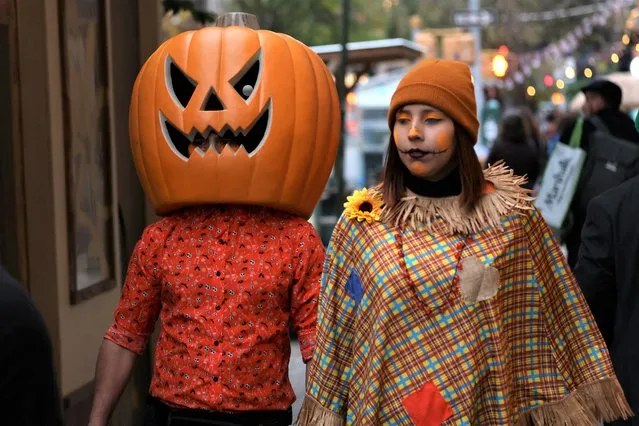 People in costumes walk through the West Village on Halloween in Manhattan, New York City, U.S., October 31, 2022. (Photo by Andrew Kelly/Reuters)