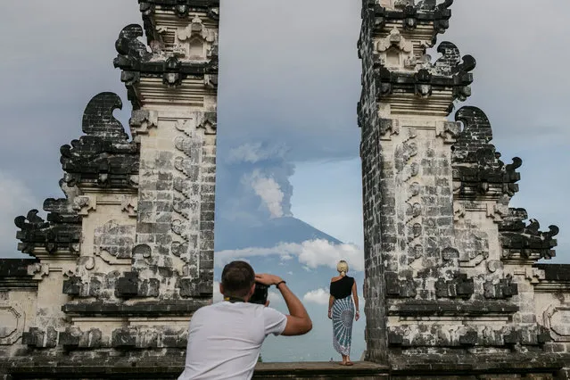Tourist take pictures as the Mount Agung volcano spewing hot volcanic ash as seen from Datah, Karangasem, Bali, Indonesia, 27 November 2017. According to media reports, the Indonesian national board for disaster management raised the alert for the Mount Agung volcano to the highest status and closed the Ngurah Rai International Airport in Bali due to the ash cloud rising from the volcano. (Photo by Made Nagi/EPA/EFE)
