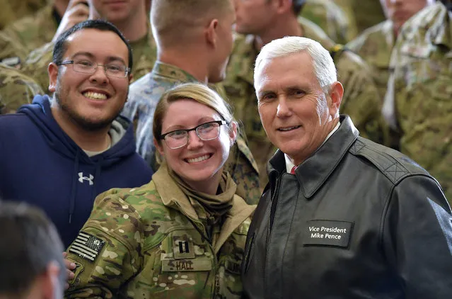 U.S. Vice President Mike Pence poses for photos with troops in a hangar at Bagram Air Field in Afghanistan on December 21, 2017. (Photo byMandel Ngan /Reuters)
