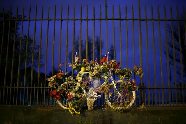 A bicycle called "Ghost bike" or "Bicianimita" hangs on a metal fence next to a road where a cyclist was killed in an accident with a vehicle in Santiago, Chile, October 1, 2015. Bicycles, usually painted in white, are a project of "Ciclistas con Alas" (Bikers with wings) organization, which seeks to make aware the many cases of run-over cyclists. The placard reads "Antonio Valdivia, 66 years, worker and cyclist. Killed by Alejandro Medina Cordero, irresponsible driver". (Photo by Ivan Alvarado/Reuters)
