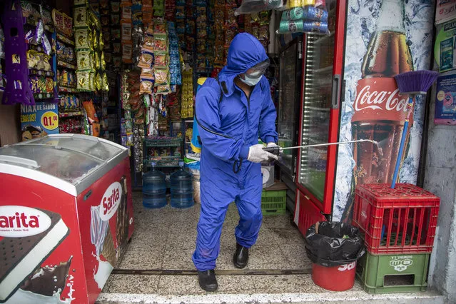 A health worker sprays disinfectant to sanitize a grocery store amid the new coronavirus pandemic in Quetzaltenango, Guatemala, Saturday, August 8, 2020. (Photo by Moises Castillo/AP Photo)