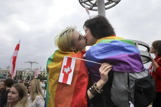 Two LGBT activists kiss while holding an old Belarusian national and rainbow's flags during an opposition rally to protest the official presidential election results in Minsk, Belarus, Saturday, September 5, 2020. For the first time in the demonstrations, supporters of LGBT rights appeared with rainbow flags in the women's march in Minsk, an indication that opponents of President Alexander Lukashenko are becoming bolder. Although same-s*x activity was legalized in Belarus in 1994, stigmatisation of it is strong. (Photo by AP Photo/Stringer)