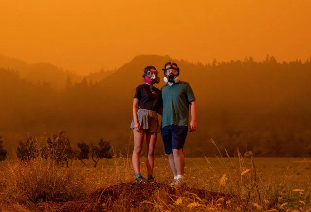 Wearing the respirator masks they have used during the pandemic, Mairead Milan and her boyfriend, Alex Loznak, pause for a portrait while heavy smoke from nearby wildfires shrouds the countryside near Elkton in rural western Oregon, US on September 8, 2020. (Photo by Robin Loznak/Zuma Press/Rex Features/Shutterstock)