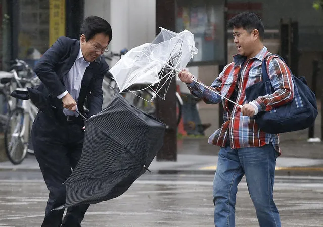 Men react as they struggle against a strong wind and rain caused by approaching Typhoon Wipha in Tokyo, October 2013. (Photo by Toru Hanai/Reuters)
