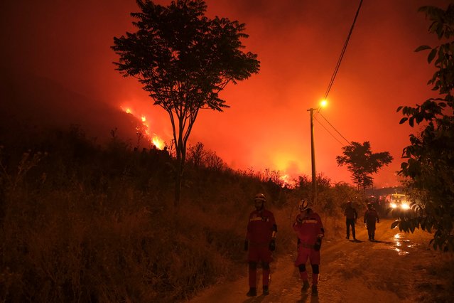 Firefighters attempt to extinguish a wildfire as smoke and flames rise from a forested area in the Gursu district of Bursa early on July 27, 2025. (Photo by Onur Yurtsever/AFP Phoot)