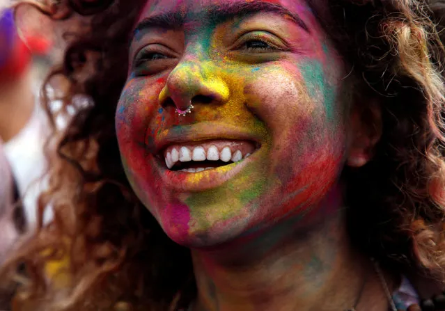 A woman, smeared with coloured powder, dance while celebrating Holi, the Festival of Colours, in Kathmandu, Nepal. (Photo by Navesh Chitrakar/Reuters)