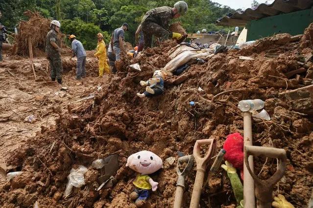 Children's toys lay in the mud where rescue workers look for bodies after a deadly landslide was triggered by heavy rains near Barra do Sahy beach in the coastal city of Sao Sebastiao, Brazil, Wednesday, February 22, 2023. (Photo by Andre Penner/AP Photo)