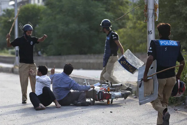 In this Sunday, August 31, 2014 file photo, Pakistani police officers baton charge motorcyclists in Islamabad, Pakistan. Human Rights Watch says Pakistan's corrupt and ill-equipped police system encourages serious rights violations, including arbitrary arrests, torture and “encounter killings” in which police stage shootouts to kill individuals in custody. (Photo by B.K. Bangash/AP Photo)