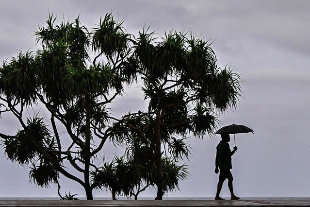 A man carrying an umbrella walks along a street amid rainfall in Colombo on May 18, 2025. (Photo by Ishara S. Kodikara/AFP Photo)