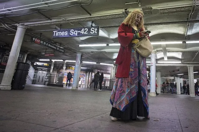 A woman dressed as a gypsy looks at her phone while waiting for a subway at Times Square station in the Manhattan borough of New York October 31, 2015. (Photo by Carlo Allegri/Reuters)