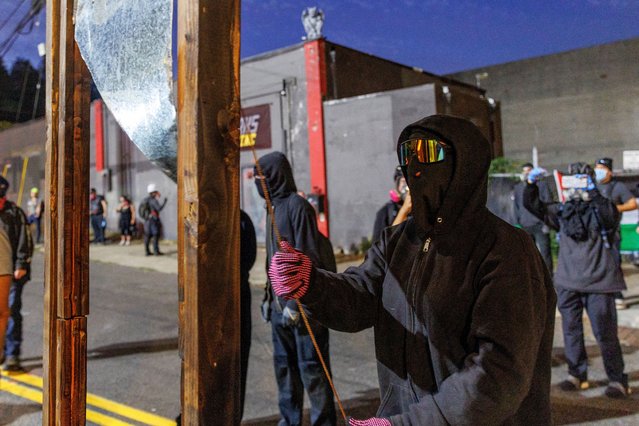 A protester holds a mockup of a guillotine as they protest outside an ICE detention facility in Portland, Oregon, U.S., on September 1, 2025. (Photo by John Rudoff/Reuters)