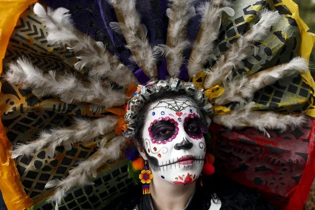 A woman with her face painted to look like the popular Mexican figure called "Catrina", poses for a photograph as she takes part in the annual Catrina Fest in Mexico City November 1, 2015. (Photo by Carlos Jasso/Reuters)