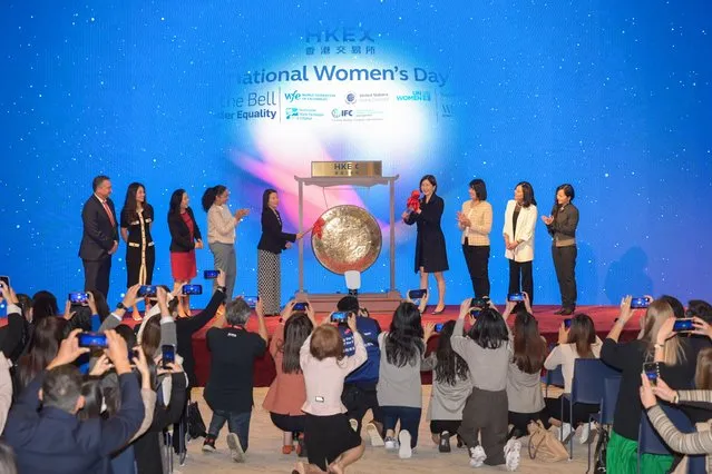 Attendents ring the gong during a ceremony held by the Hong Kong Exchanges and Clearing Limited (HKEX) to mark the International Women's Day at the HKEX Connect Hall on March 8, 2023 in Hong Kong, China. (Photo by Chen Yongnuo/China News Service/VCG via Getty Images)