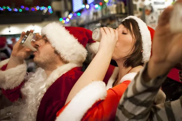 Santarchy participants drink shots at The Pine Box in Seattle, Washington December 13, 2014. (Photo by David Ryder/Reuters)