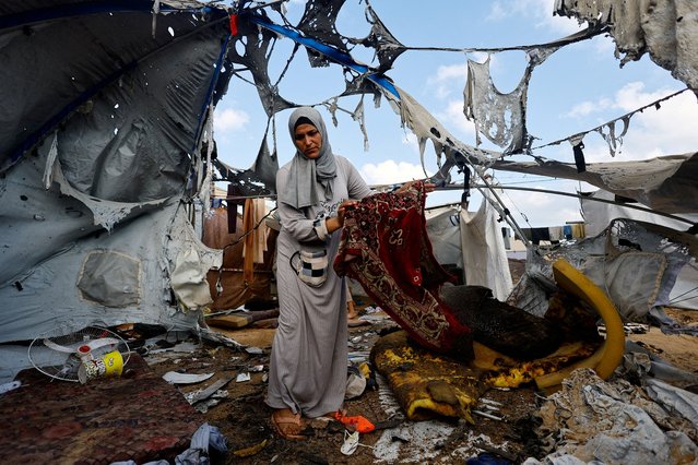 A Palestinian woman carries a prayer mat at the site of an overnight Israeli strike on a tent, in Gaza City on September 8, 2025. (Photo by Mahmoud Issa/Reuters)