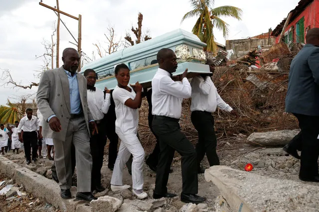 People carry the coffin of a woman who died during Hurricane Matthew in front of destroyed houses in Jeremie, Haiti, October 11, 2016. (Photo by Carlos Garcia Rawlins/Reuters)