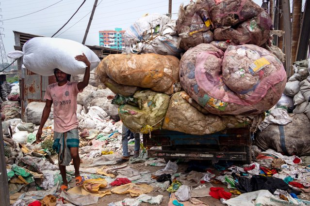 A worker transports sacks of discarded plastic bags near the Buriganga River in Dhaka, Bangladesh on October 16, 2025. (Photo by Joy Saha/ZUMA Press Wire/Rex Features/Shutterstock)