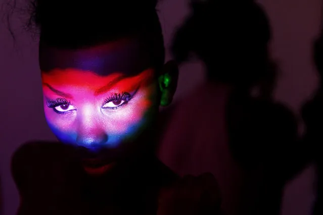 Coloured lights are reflected onto the face of model Sira Sissoko as she waits backstage during Dakar Fashion Week July 16, 2010. (Photo by Finbarr O'Reilly/Reuters)