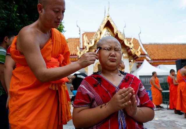 A young hill tribe boy reacts as his hair and eyebrows are shaved off by a Thai Buddhist monk during a head shaving rite of a mass Buddhist monk ordination ceremony for hill tribe men and youngsters at Wat Benchamabophit, also known as the Marble Temple in Bangkok, Thailand, 05 July 2024. A total of 191 hill tribe men including young boys were to be ordained as Buddhist monks and novices in the annual mass ordination ceremony to mark the three-month Buddhist Lent which this year begins on 21 July as well as to honor the King's 72nd birthday anniversary on 28 July. For the duration of the Buddhist Lent, monks remain in one location, typically in a monastery or on temple grounds, where they engage in meditation and prayer, while laymen choose to observe Lent by giving up meat, alcohol, and perform other ascetic practices. In Thailand, a Buddhist man is expected to become a monk during some period of his life. (Photo by Rungroj Yongrit/EPA/EFE)