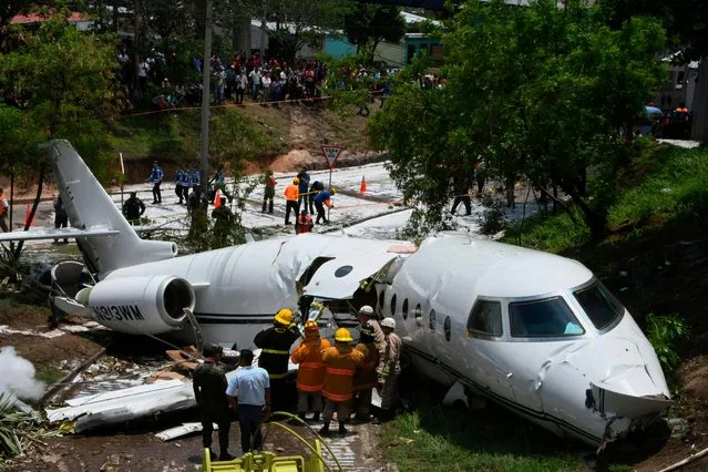 A white Gulfstream jet that appears broken in half near the center, lies engulfed in foam sprayed by firefighters, in Tegucigalpa, Honduras, Tuesday, May 22, 2018. The private jet crashed off the end of the runway at Tegucigalpa' s airport Tuesday, but the crew and passengers were rescued and reportedly out of danger, according to Honduras emergency management agency. (Photo by Fernando Antonio/AP Photo)