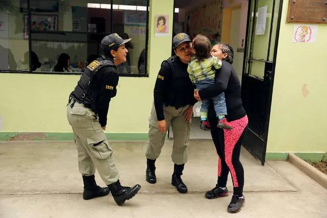 Guards and an inmate play with a child at a nursery school inside Santa Monica women's prison in Lima, Peru, October 31, 2016. (Photo by Mariana Bazo/Reuters)