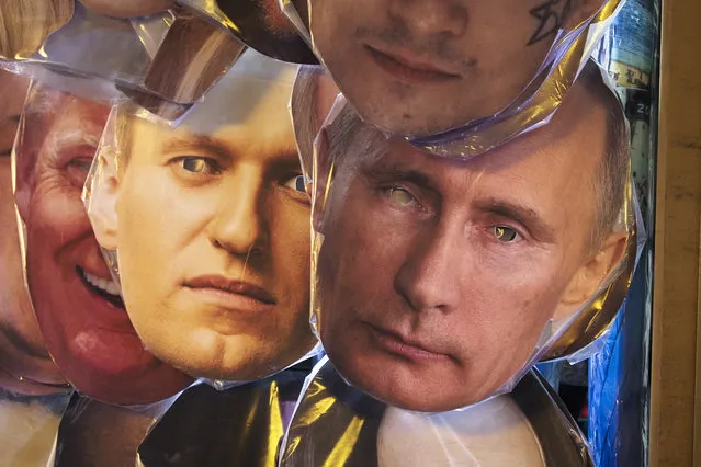 Face masks depicting Russian President Vladimir Putin, right, and Russian opposition leader Alexei Navalny, left of Putin, among others displayed for sale at a street souvenir shop in St.Petersburg, Russia, Sunday, January 17, 2021. Top Kremlin critic Alexei Navalny says he will fly home to Russia on Sunday, Jan. 17, 2021, despite the Russian prison service's intention to put him behind bars for allegedly breaching the terms of his suspended sentence and probation. (Photo by Dmitri Lovetsky/AP Photo)