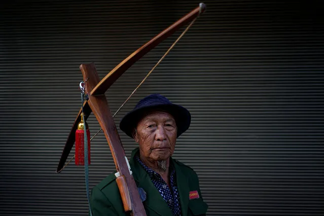 An ethnic Lisu man carries his crossbow as he poses for a photograph during a crossbow shooting competition in Luzhang township of Nujiang Lisu Autonomous Prefecture in Yunnan province, China, March 29, 2018. (Photo by Aly Song/Reuters)